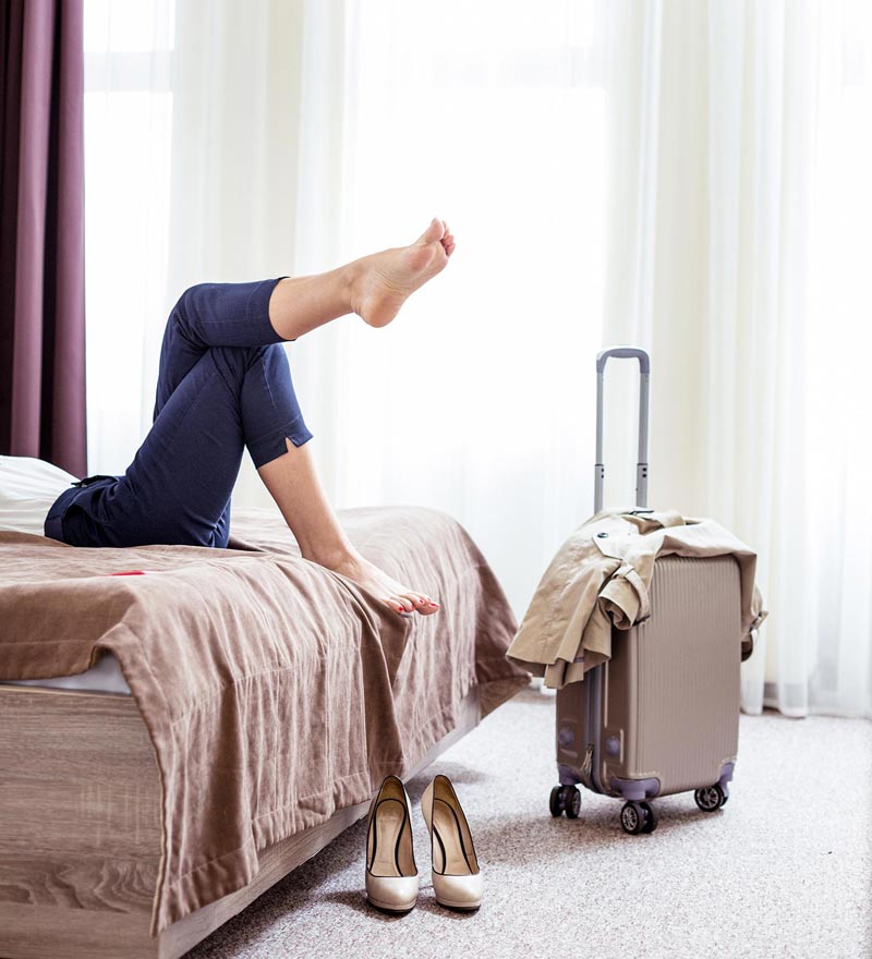 Frau im Hotelzimmer mit Koffer