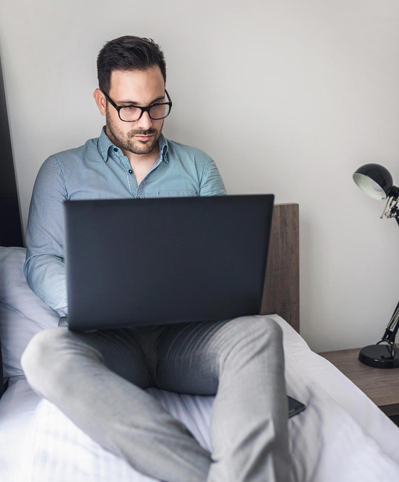 Man on bed with laptop